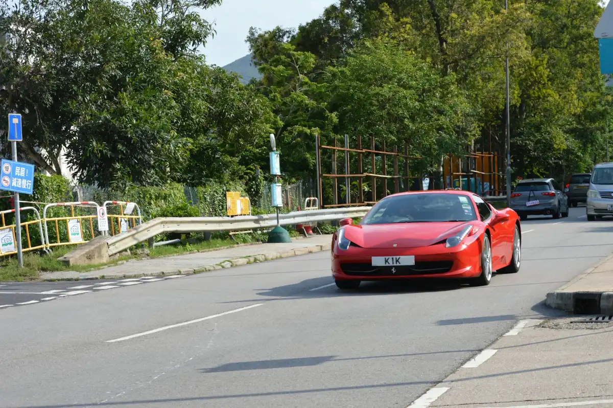 a red sports car driving down a street
