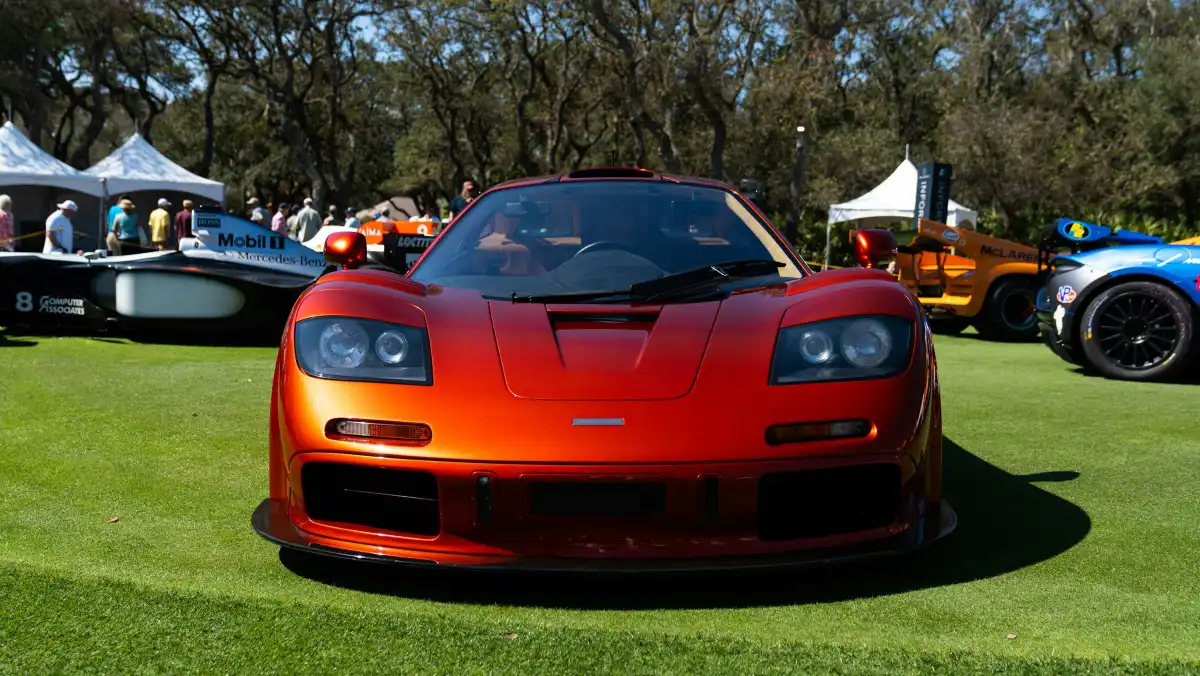 a red sports car parked on top of a lush green field