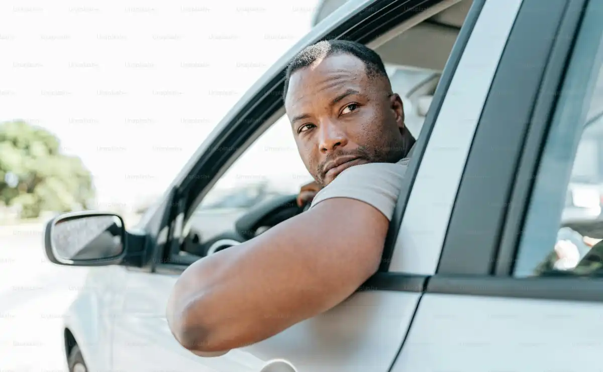 a man leaning his head out of a car window