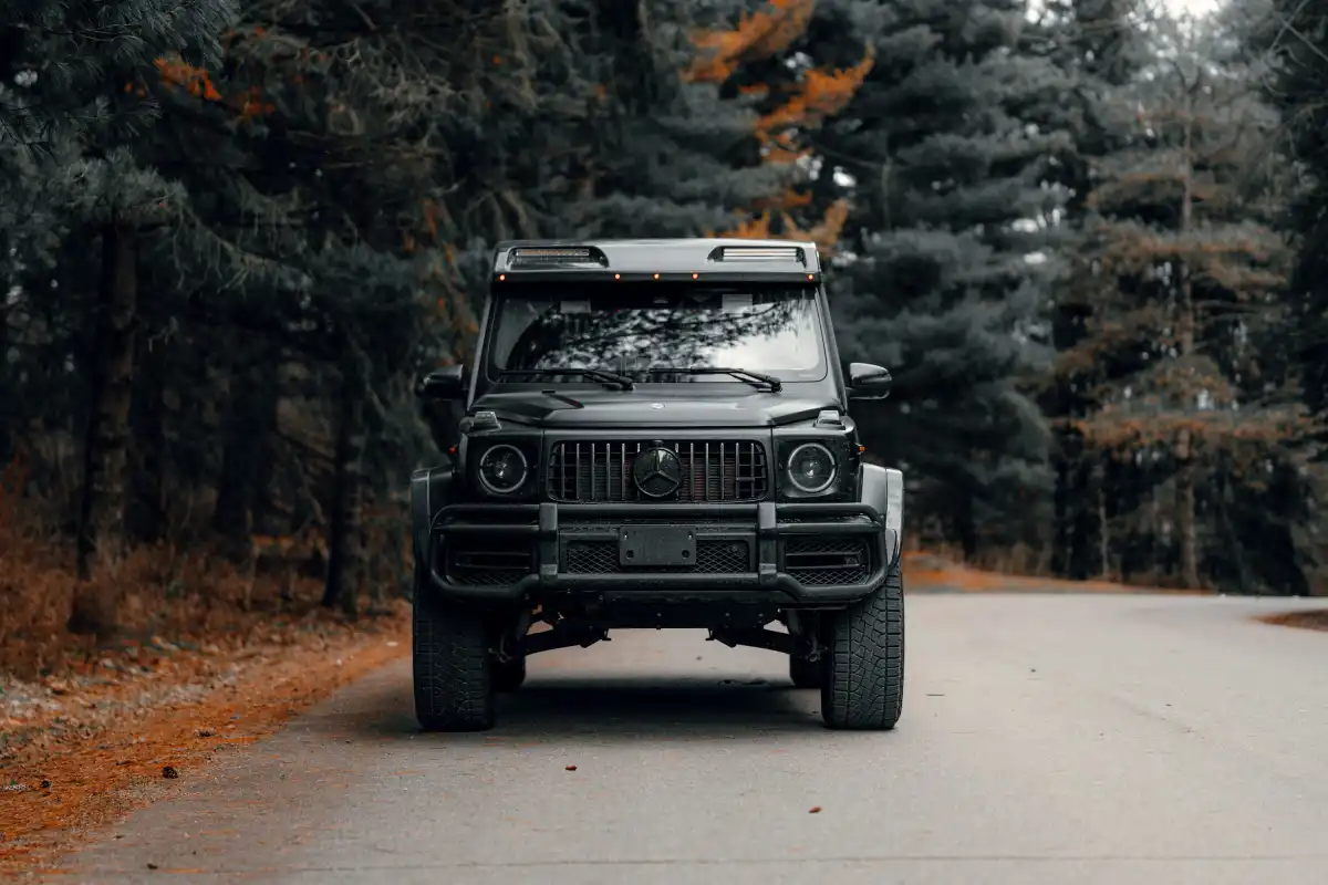A jeep driving down a road in the woods