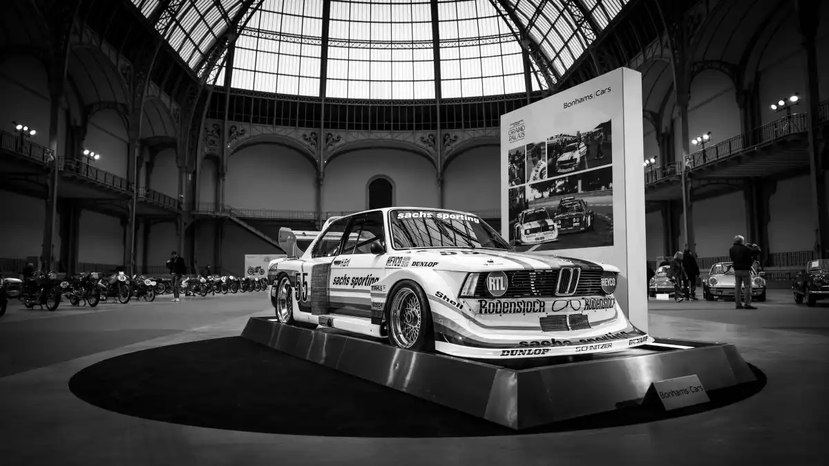 A black and white photo of a car on display