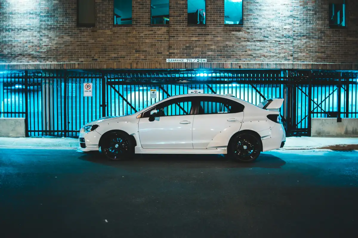 white coupe parked beside building during daytime