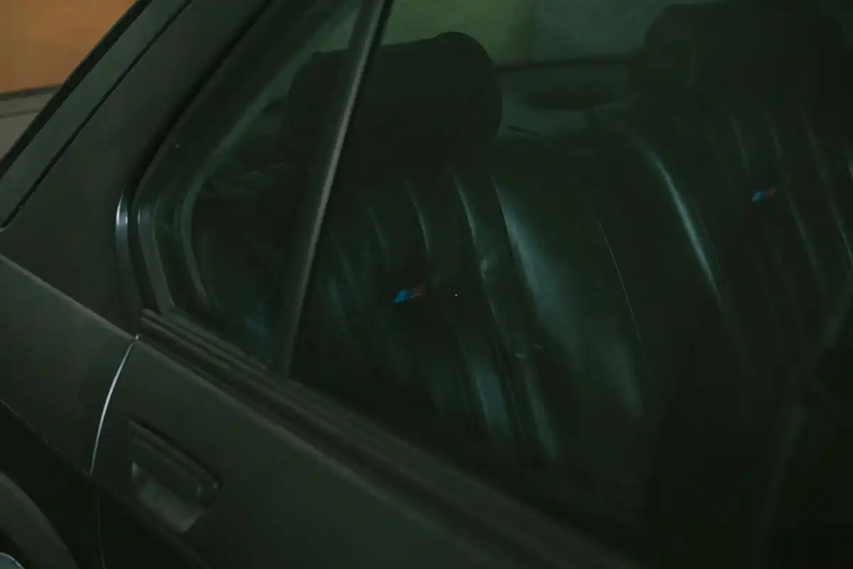 Dark leather car seats seen through window