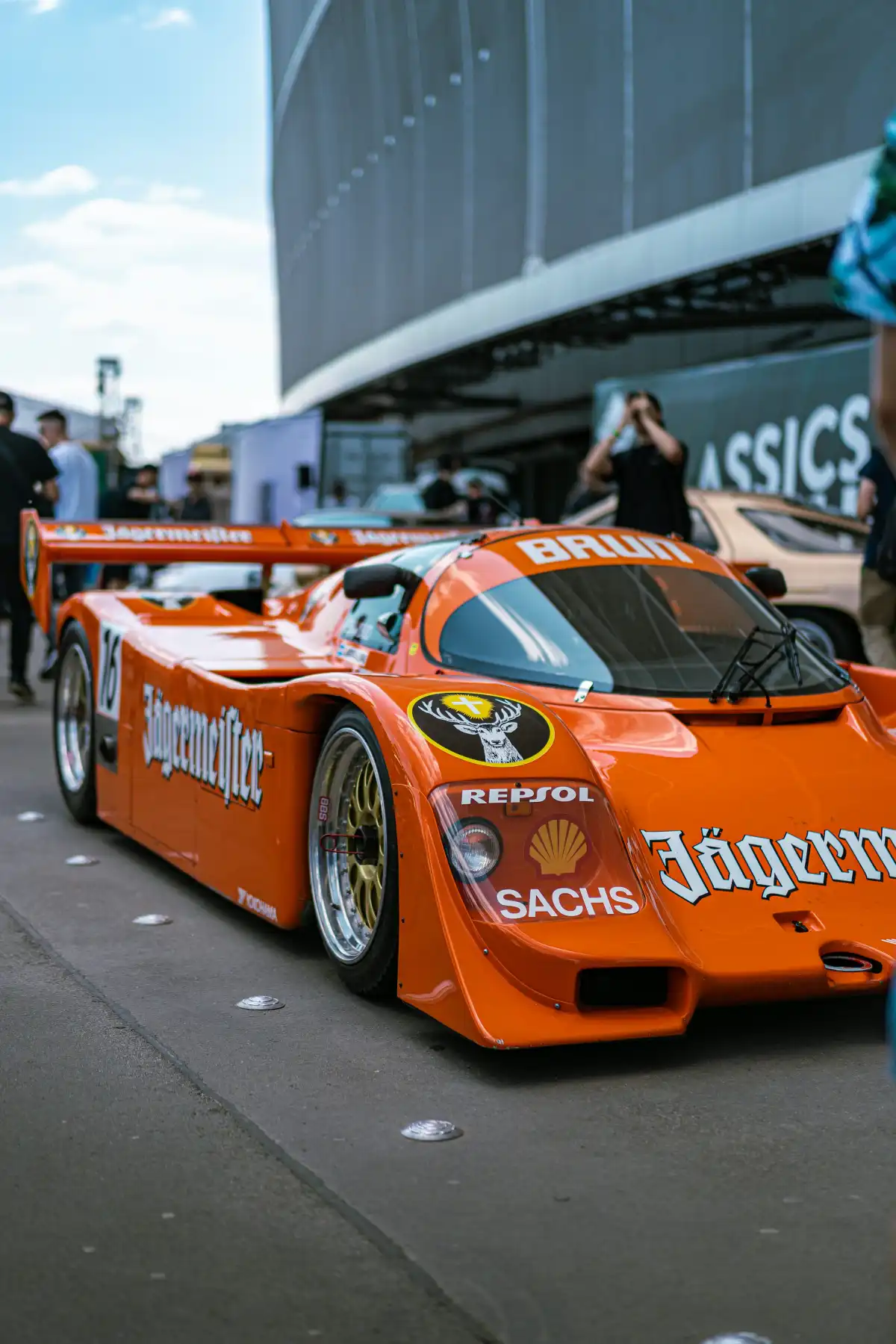 an orange race car parked in front of a building